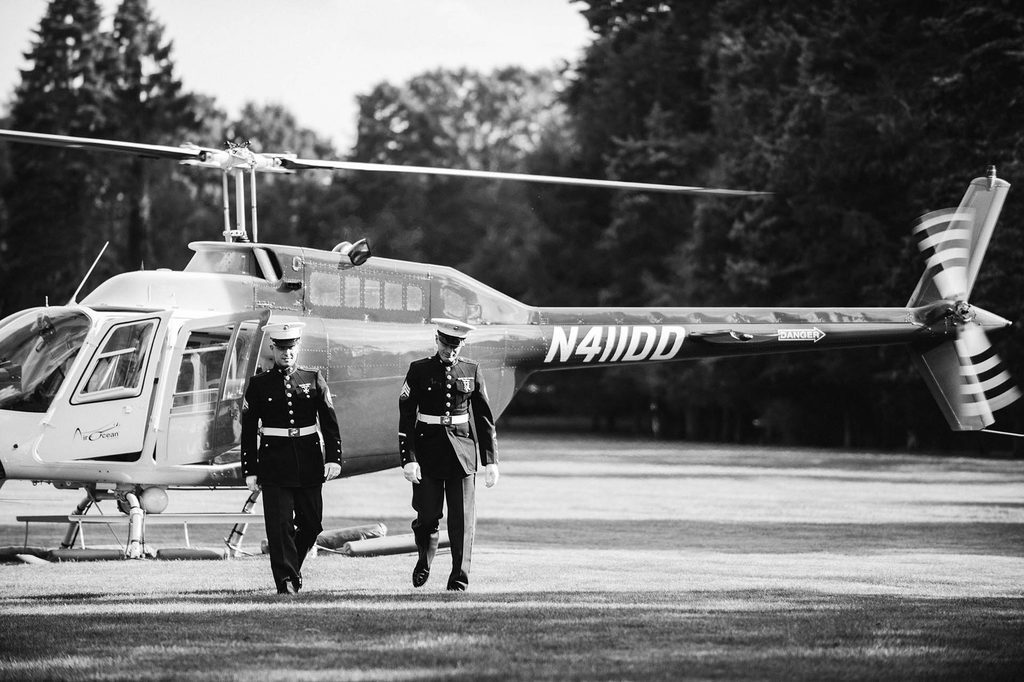Black and White wedding photo of the groom, a U.S. Marine in uniform, arriving to the ceremony by helicopter at The Wadsworth Mansion