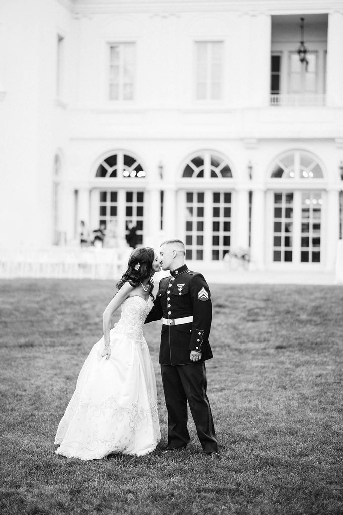 Black and White wedding photo of the bride and groom (a U.S. Marine in uniform) kissing on the lawn at The Wadsworth Mansion